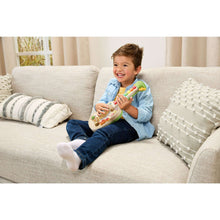 Child holding a wooden strum-and-count guitar toy with colorful number keys