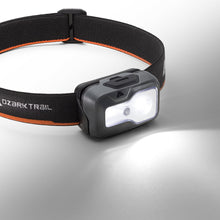 LED headlamp on black-and-orange strap, white beam shown on front panel