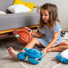 Sea turtle plush set with orange and blue turtles, held by children