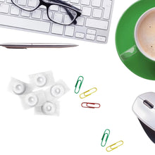 Individually wrapped mint pieces with binder clips on a white surface