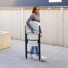White folding chair with perforated plastic seat and back, black metal frame