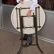 Round bistro table with light perforated top and black folding support frame
