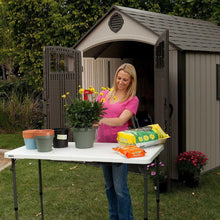 Adjustable fold-in-half table with white top and four black metal legs