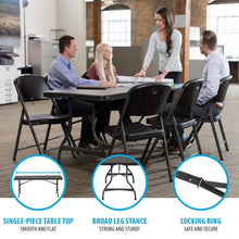 Folding stacking table with black top, broad arched legs and locking ring base