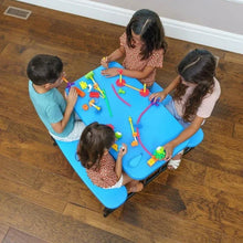 Blue kids picnic table with two bench seats, surrounded by children playing.