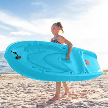 Blue youth sit-on-top kayak on sand with child standing on deck.