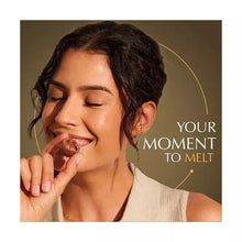 Person smiling while tasting a chocolate truffle, on Lindor bag insert