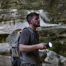 LitezAll LED flashlight in hand, front head lit for outdoor use.
