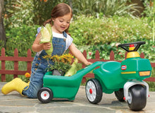Green ride-on tractor with yellow seat and attached cart, four wheels