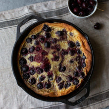Round cast iron skillet holding a baked berry dessert