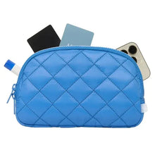Blue quilted belt bag with zipper top and open card and phone in pocket