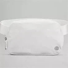 Lululemon Athletica belt bag 1L in white, side profile with zipper pull and logo