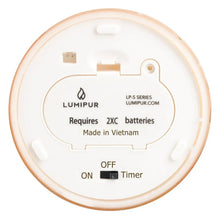 Battery compartment underside of a flameless LED glass candle, showing electronics and label.