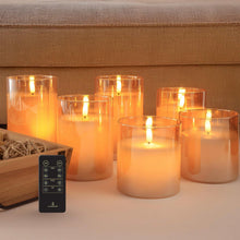 Flameless LED pillar candle set in amber glass on tabletop, with glowing LED flames and remote.