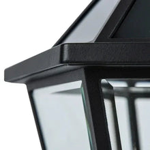 Close-up of black lantern frame corner and clear glass panel on a solar post light