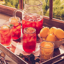 Decaffeinated iced tea in clear jars and glasses with ice and lemon slices