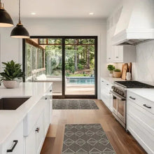 Dark jute runner rug with gray geometric triangle pattern along kitchen floor.