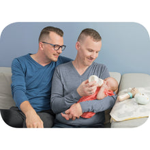 Family feeding scene with a baby holding an anti-colic bottle