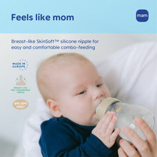 Baby holding a glass baby bottle with silicone nipple and sea animal design