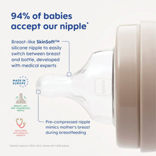 Clear baby bottle with pre-compressed nipple and beige rim, close-up side view