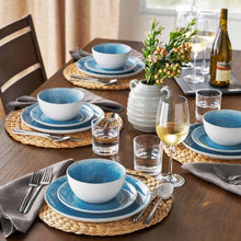 Blue speckled artisan dinnerware set with plates, bowls, and mugs