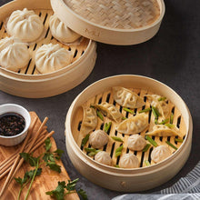 Two bamboo steamer baskets with woven lids, filled with dumplings