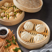 Bamboo steamer basket with dumplings on wooden slats, beige