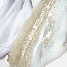Creamy exfoliating body scrub with fine golden particles and white foam