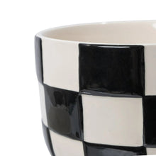 Ceramic planter close-up: glossy black-and-white checker pattern with white rim