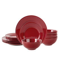 Red stoneware dinner plate set with dotted rim, stack of plates and bowls