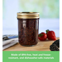 Half-pint mason jar with brass lid and ring, filled with dark berry preserves