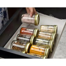 Half pint glass canning jars with gold lids and rings, shown in a tray set