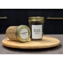 Small glass canning jars with gold lids and rings, one holding peppercorns