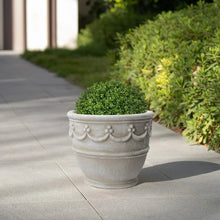 Cream ceramic planter with wave embossing holding small greenery