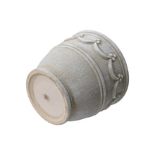 Cream ceramic planter with wave embossing and round drainage hole base