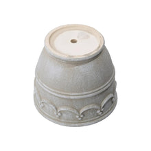 Cream ceramic planter with wave embossed body and drainage hole on base