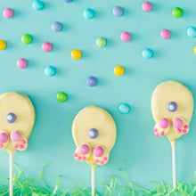 Pastel egg-shaped lollipop candies with blue candy sprinkle details