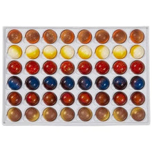 Tray of assorted gourmet chocolate bonbons with blue, red, yellow, and brown pieces