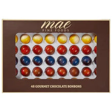 Box of assorted gourmet chocolate bonbons with round pieces in a window