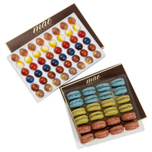 Assorted gourmet chocolate bonbons in a clear tray with colorful rounds