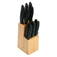 Stainless steel knife set with black handles in bamboo storage block.