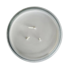 Scented candle top view with three white wicks in clear glass jar