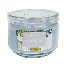 Unlit blue glass jar candle with Beachside Linen label, 11.5 oz, side view