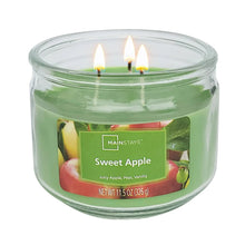 Green glass jar candle with Sweet Apple label and three lit wicks