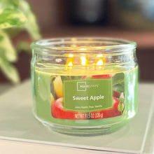Green glass jar candle close-up with three wicks burning