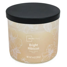 Amber scented candle with black lid and white floral design on jar