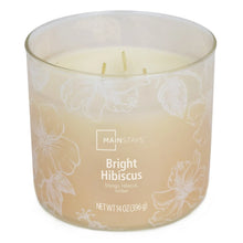 Amber scented candle with three burning wicks and white floral pattern on jar
