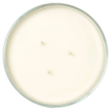 Unlit candle wax top in clear glass lid with three wick tips