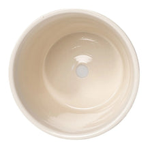 Round ceramic planter base with central drainage hole, off-white interior