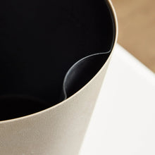 Beige self-watering planter interior with smooth dark basin rim